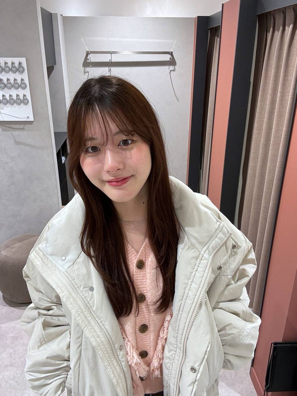 ホワイト系のその他アウター、ブラウン系のスカート、ピンク系のカーディガン/ボレロを着用したレディースの冬コーディネートの4枚目の写真