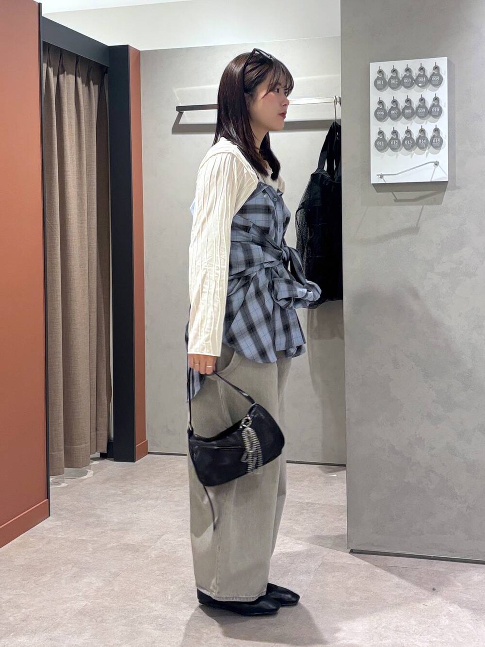 グレー系のデニムパンツ、ブラック系のバレエシューズ、ブラック系のトートバッグを着用したレディースの春コーディネートの2枚目の写真