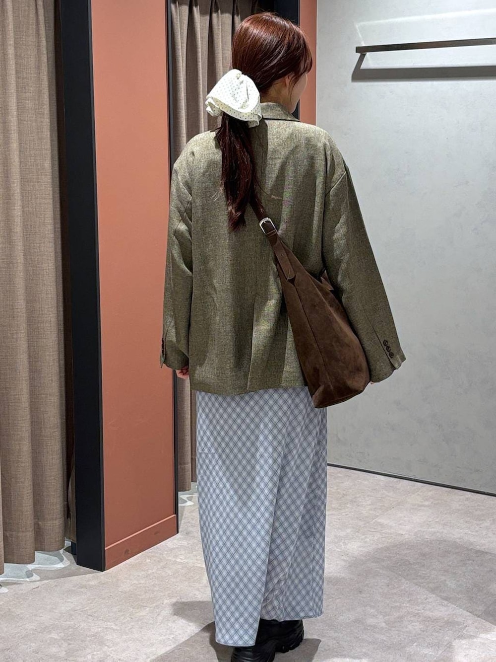 ブラウン系のショルダーバッグ、ブラウン系のテーラードジャケット、ブラック系のローファーを着用したレディースの春コーディネートの3枚目の写真