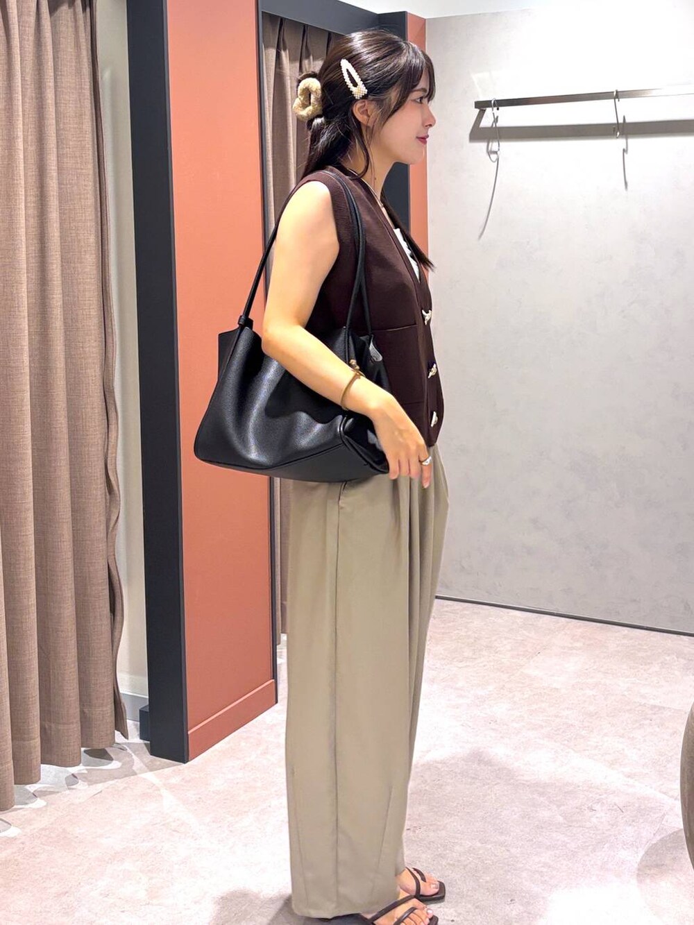 ブラウン系のサンダル、ベージュ系のその他パンツ、ブラック系のショルダーバッグを着用したレディースの夏コーディネートの2枚目の写真