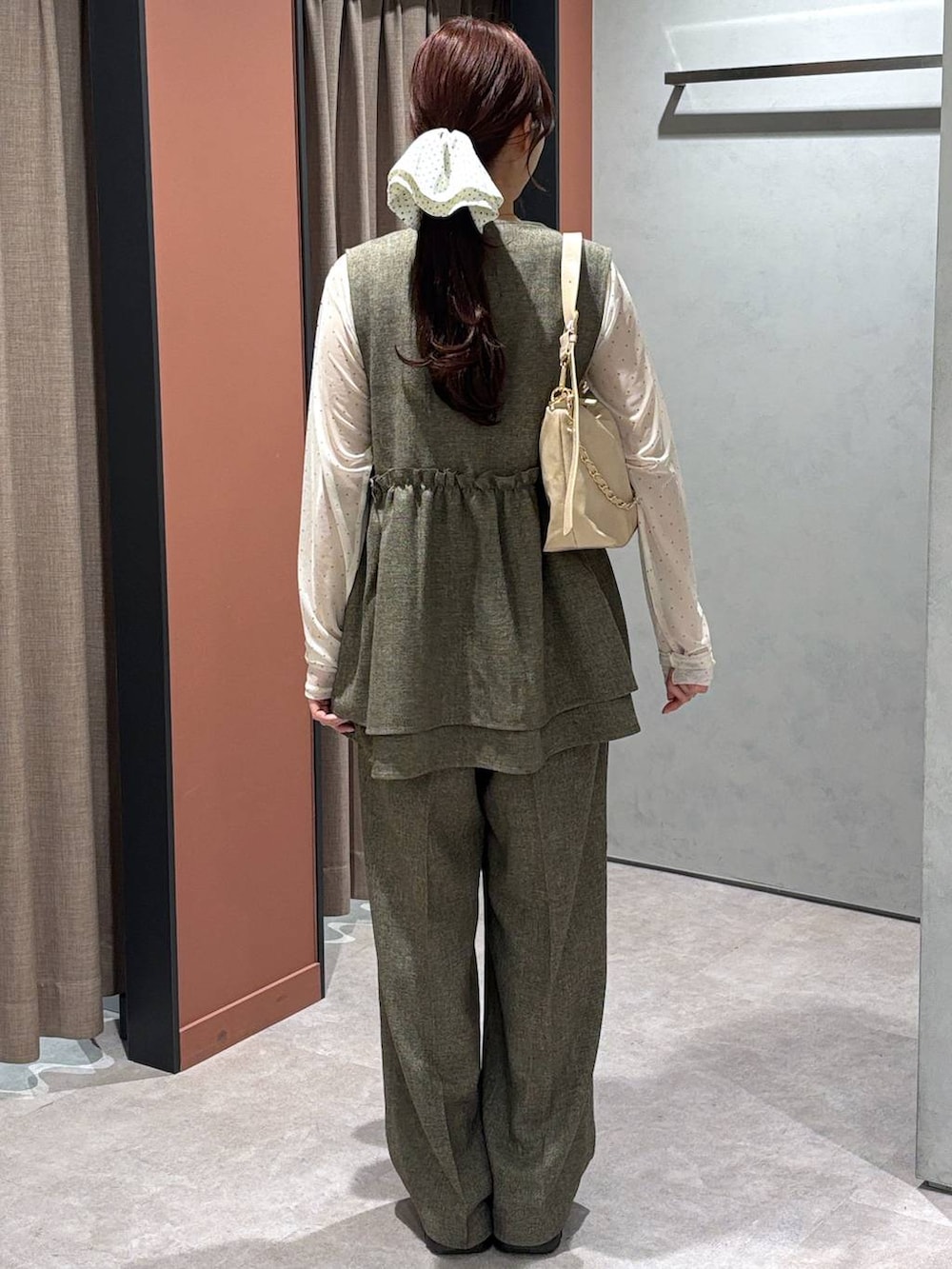 ブラウン系のデニムパンツ、ブラウン系のベスト、ホワイト系のTシャツ/カットソーを着用したレディースの冬コーディネートの3枚目の写真