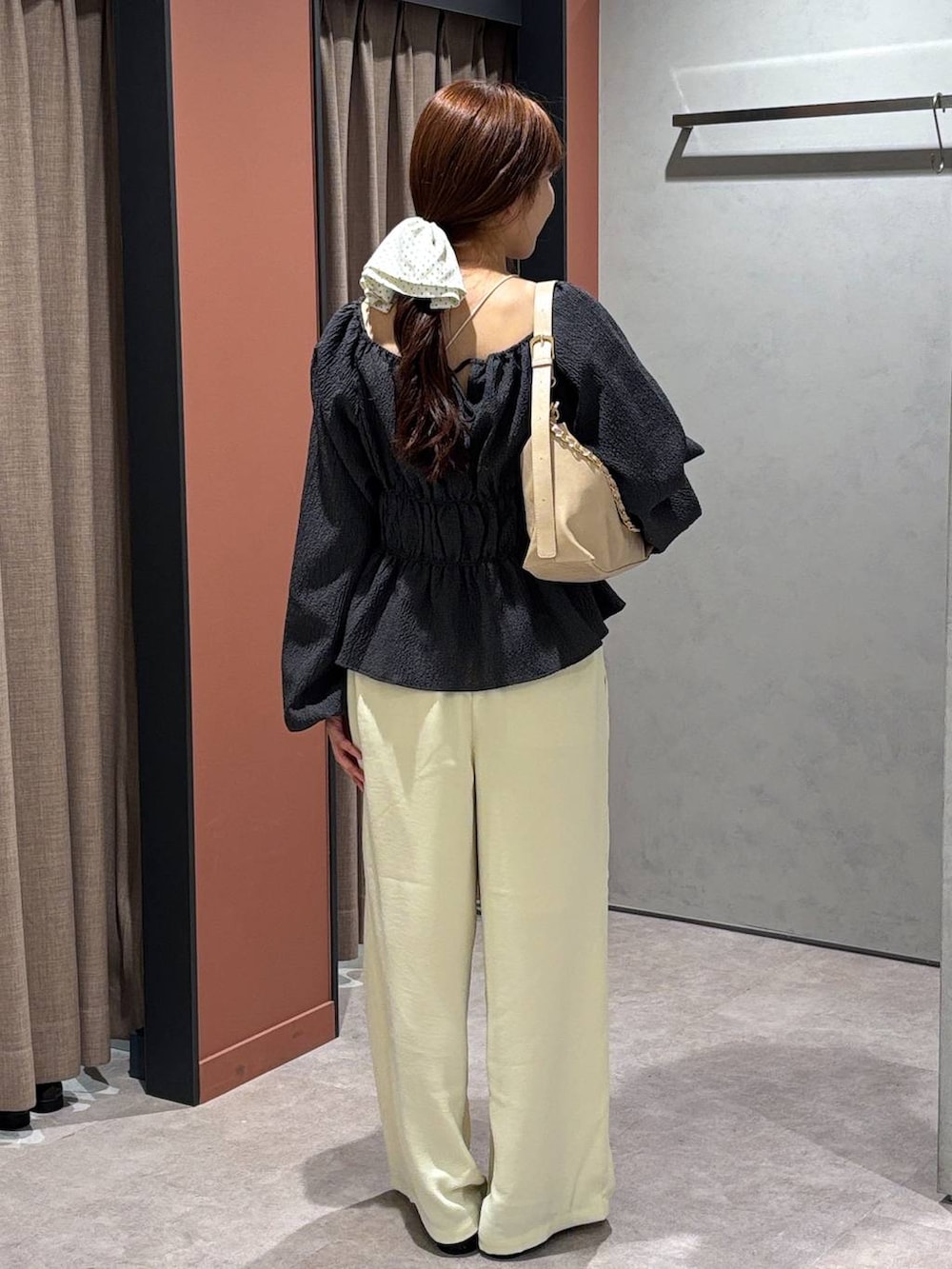 ブラック系のパンプス、ベージュ系のショルダーバッグ、イエロー系のその他パンツを着用したレディースの春コーディネートの3枚目の写真