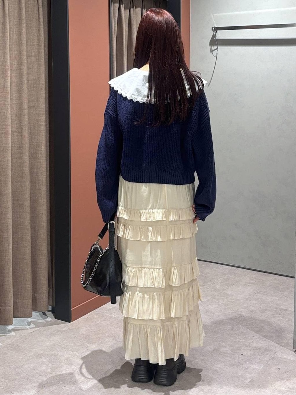 ブラック系のショルダーバッグ、ブラウン系のローファー、ホワイト系のスカートを着用したレディースの冬コーディネートの3枚目の写真