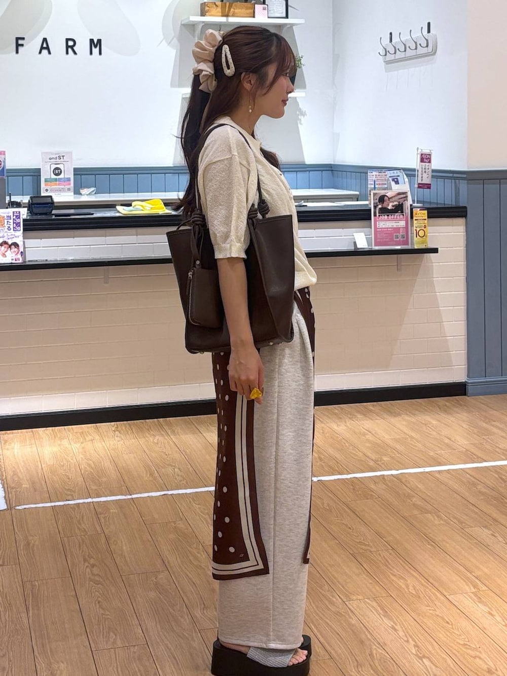 グレー系のスウェットパンツ、シルバー系のサンダル、ブラウン系のトートバッグを着用したレディースの春コーディネートの3枚目の写真