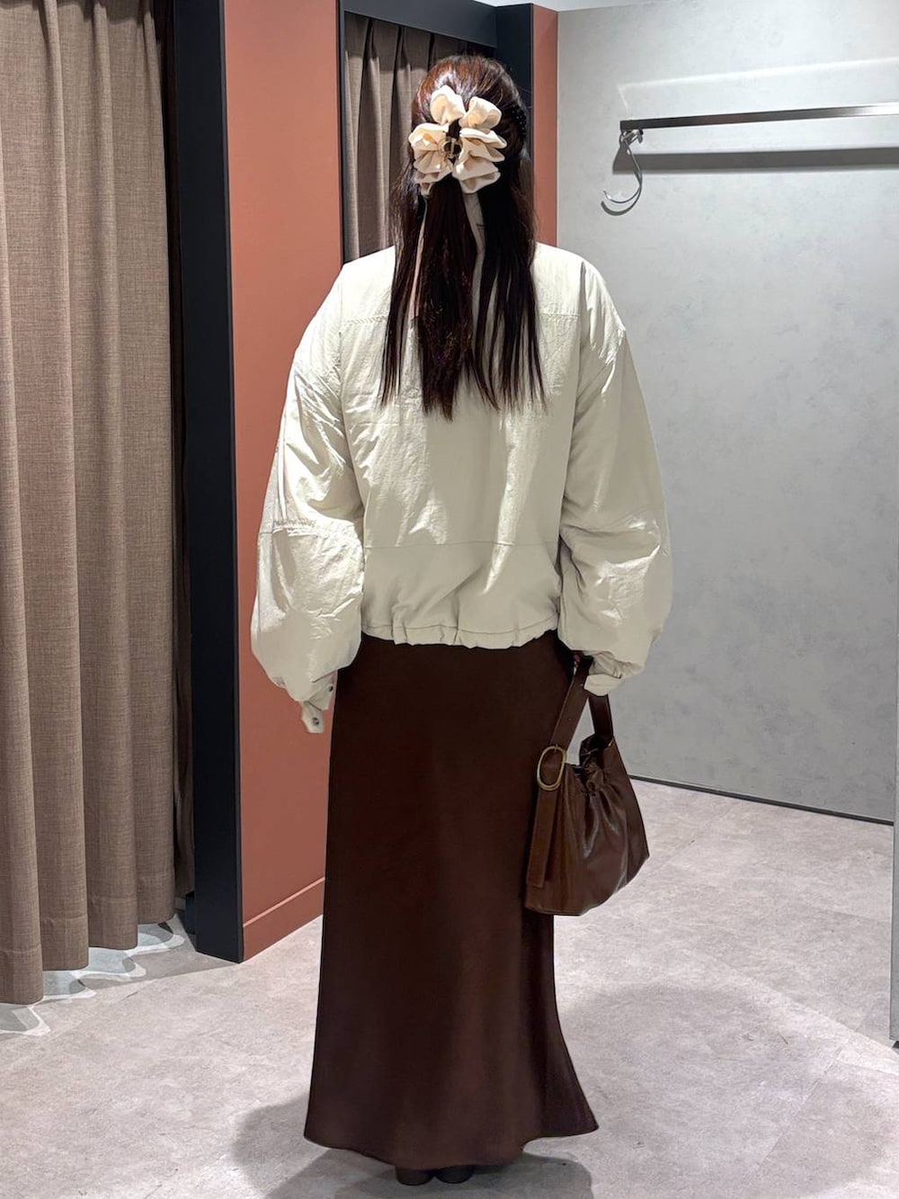 ホワイト系のその他アウター、ブラウン系のスカート、ブラウン系のショルダーバッグを着用したレディースの冬コーディネートの3枚目の写真