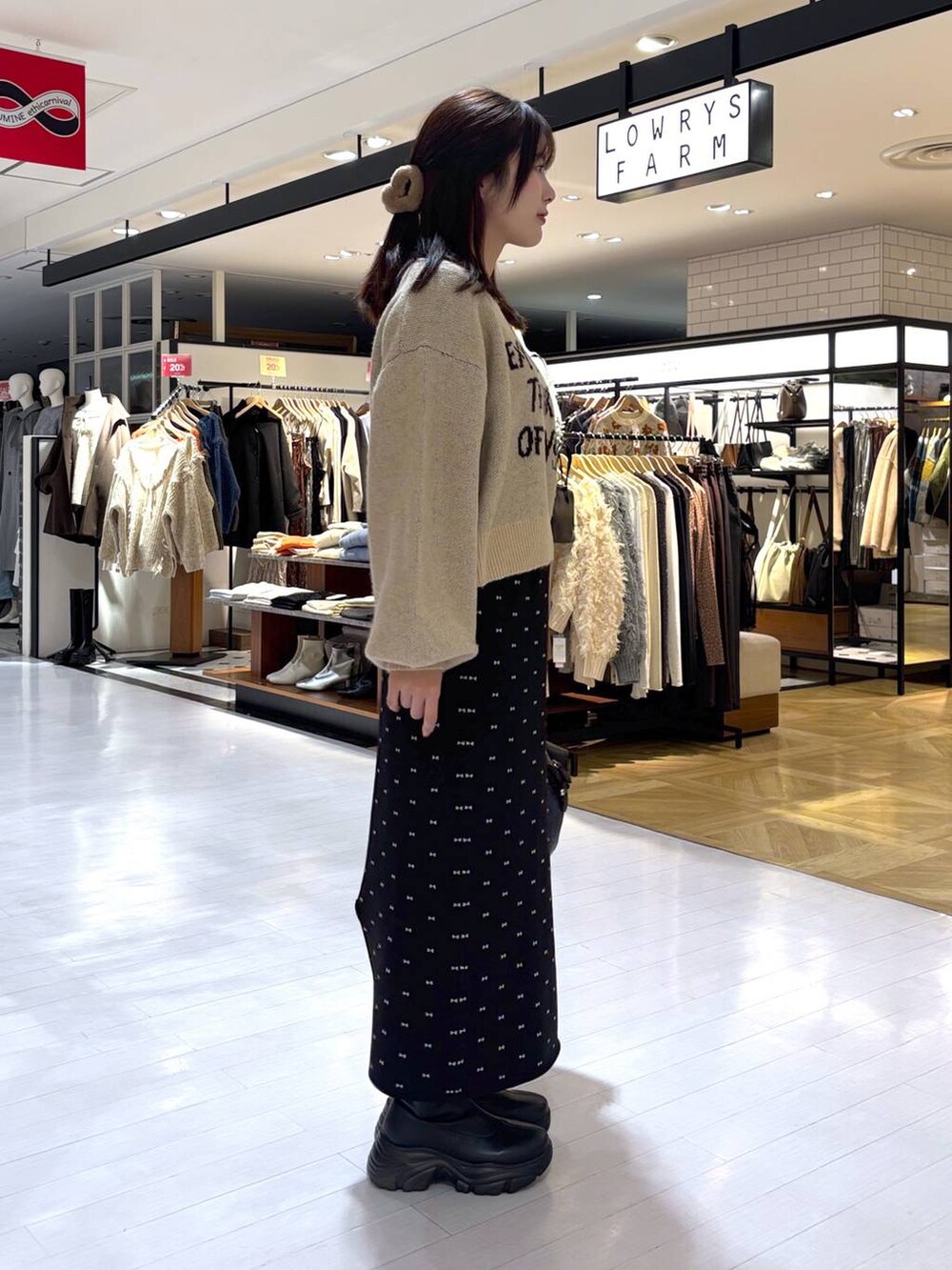 ブラック系のスカート、ブラック系のブーツ、ブラック系のショルダーバッグを着用したレディースの冬コーディネートの2枚目の写真