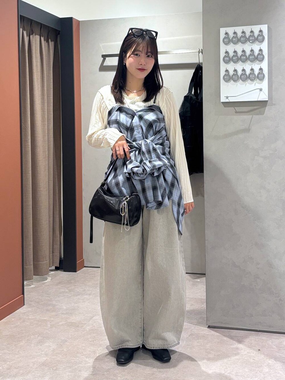 グレー系のデニムパンツ、ブラック系のバレエシューズ、ブラック系のトートバッグを着用したレディースの春コーディネートの5枚目の写真