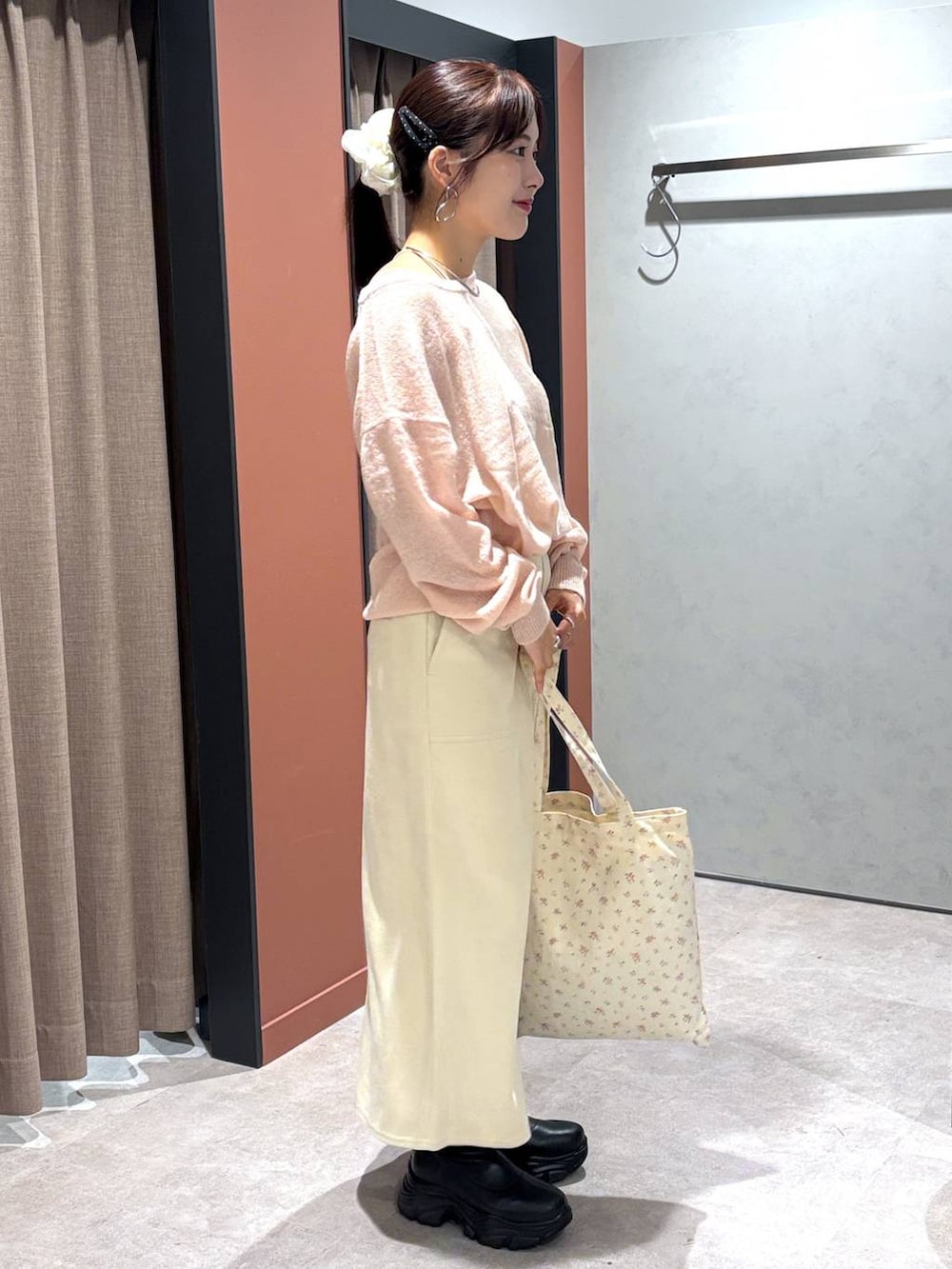 ブラック系のブーツ、その他のトートバッグ、ピンク系のニット/セーターを着用したレディースの秋コーディネートの2枚目の写真