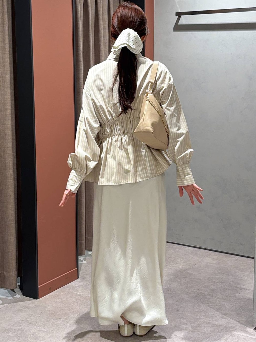 ホワイト系のスカート、ベージュ系のショルダーバッグ、ホワイト系のパンプスを着用したレディースの春コーディネートの3枚目の写真