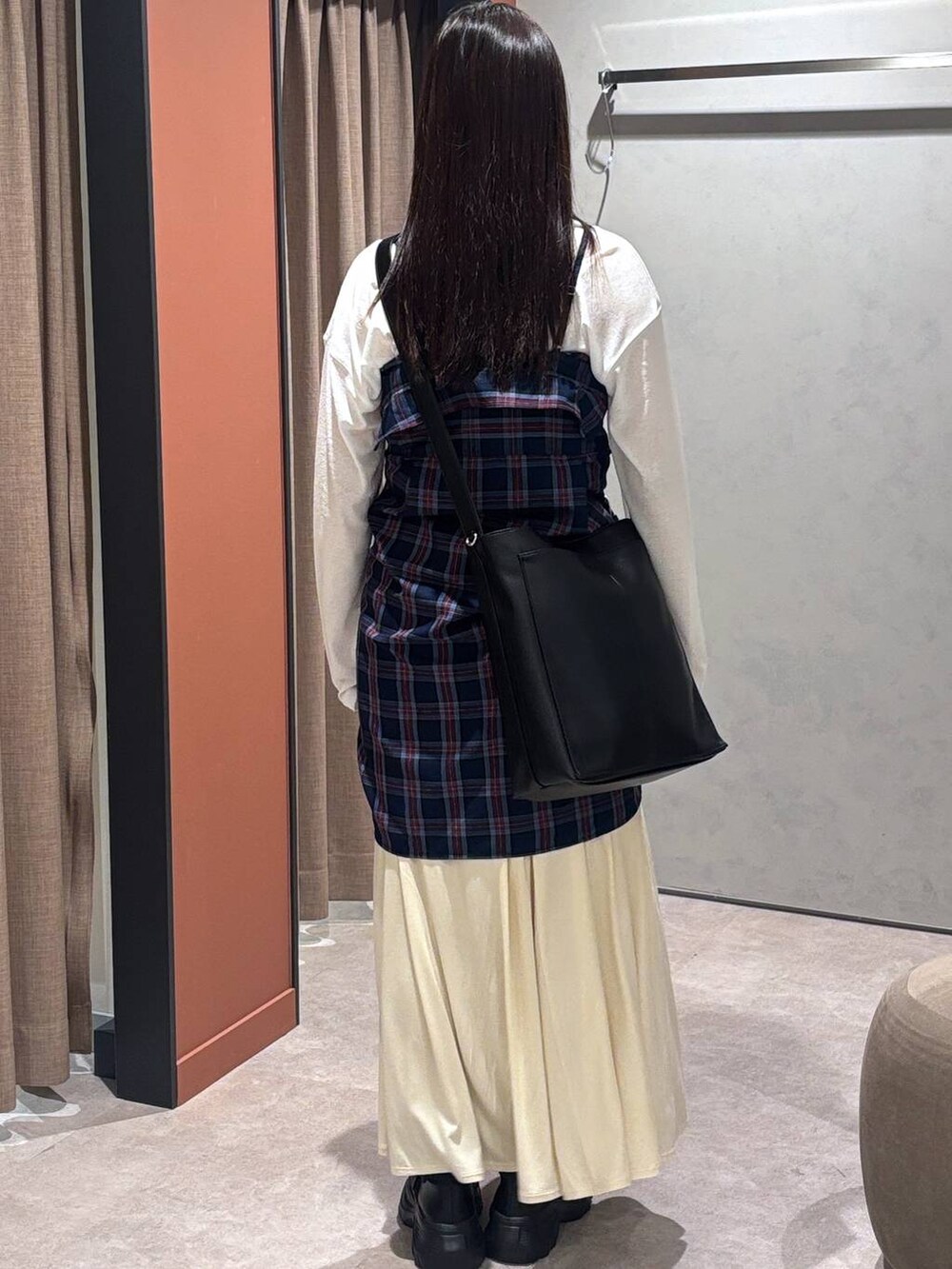 ブラック系のスニーカー、ホワイト系のスカート、ブルー系のシャツ/ブラウスを着用したレディースの秋コーディネートの3枚目の写真