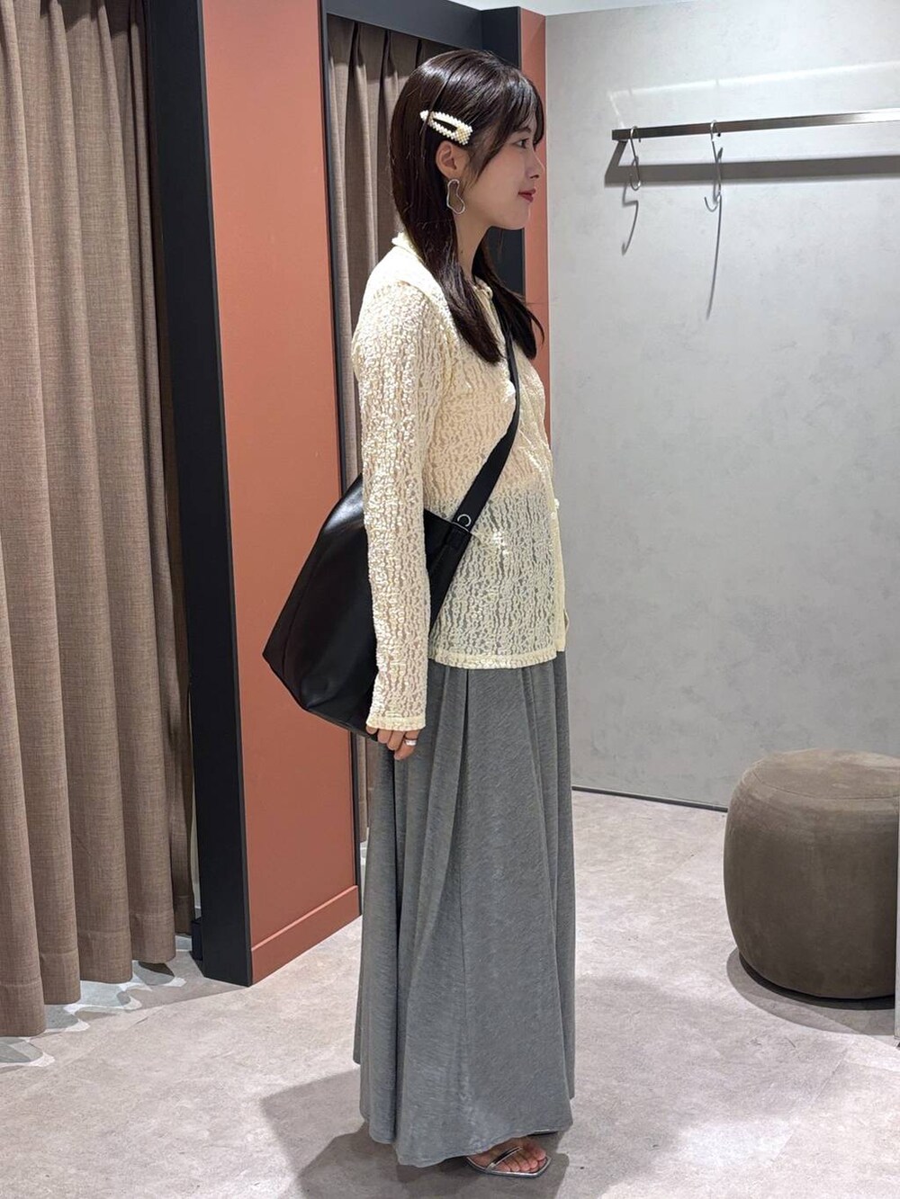 シルバー系のサンダル、グレー系のスカート、ブラック系のショルダーバッグを着用したレディースの夏コーディネートの2枚目の写真