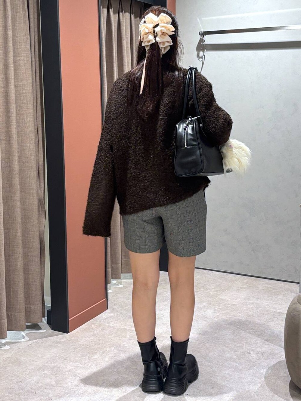 ブラック系のブーツ、その他のその他パンツ、ブラック系のボストンバッグを着用したレディースの秋コーディネートの3枚目の写真