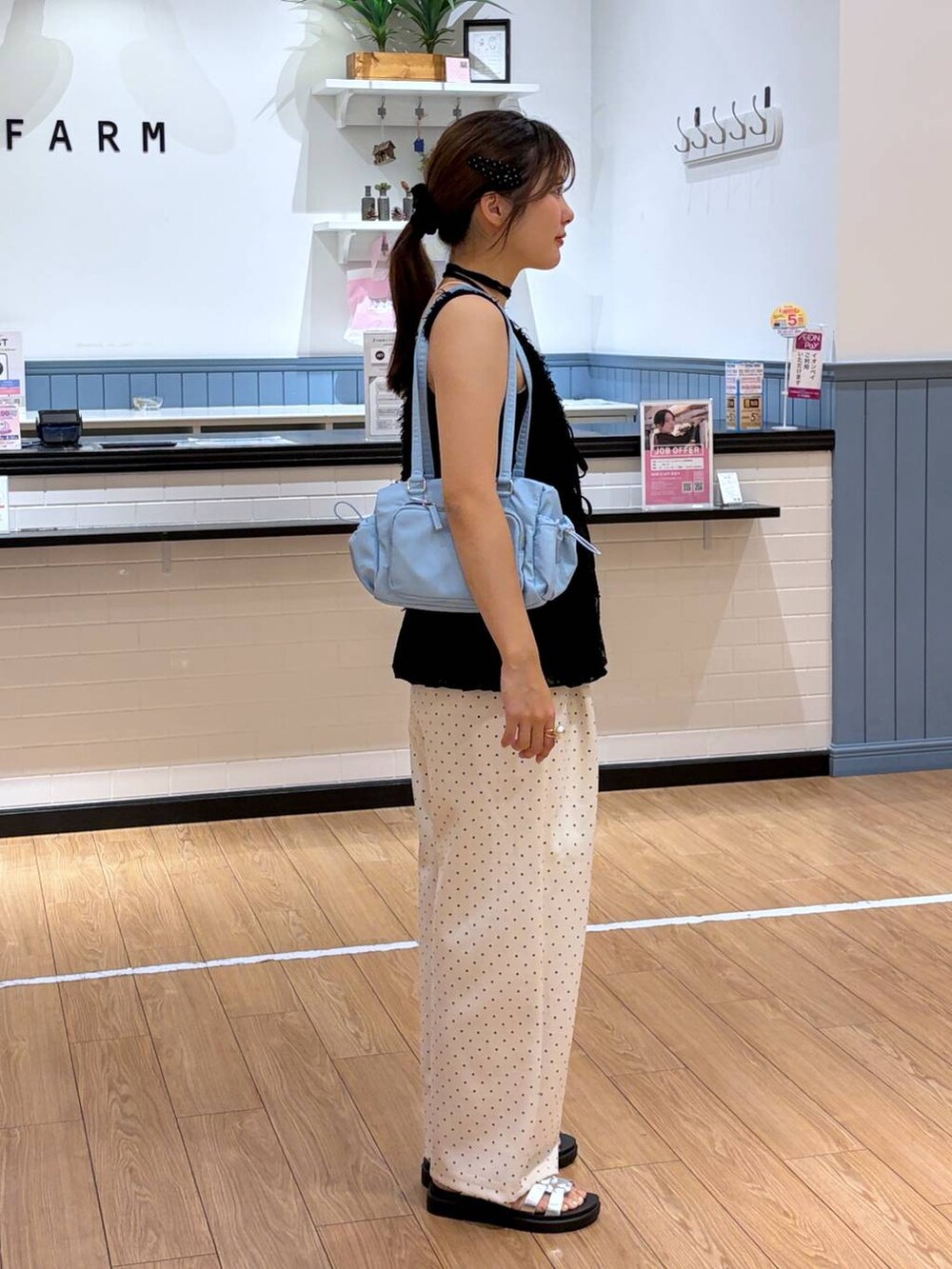 ホワイト系のスウェットパンツ、シルバー系のサンダル、ブラック系のベストを着用したレディースの夏コーディネートの2枚目の写真