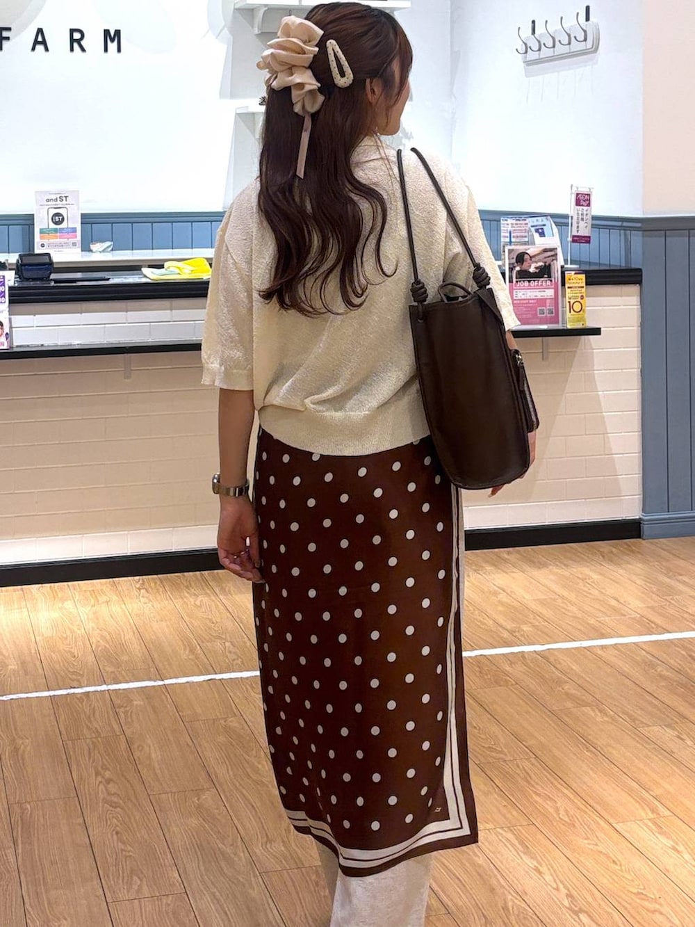 グレー系のスウェットパンツ、シルバー系のサンダル、ブラウン系のトートバッグを着用したレディースの春コーディネートの2枚目の写真
