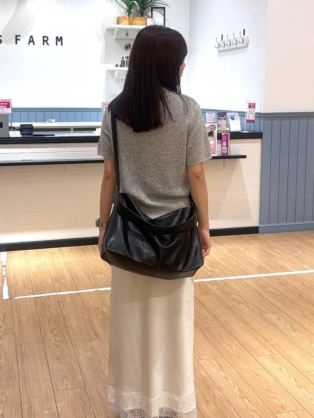ホワイト系のサンダル、グレー系のTシャツ/カットソー、ブラック系のショルダーバッグを着用したレディースの春コーディネートの3枚目の写真