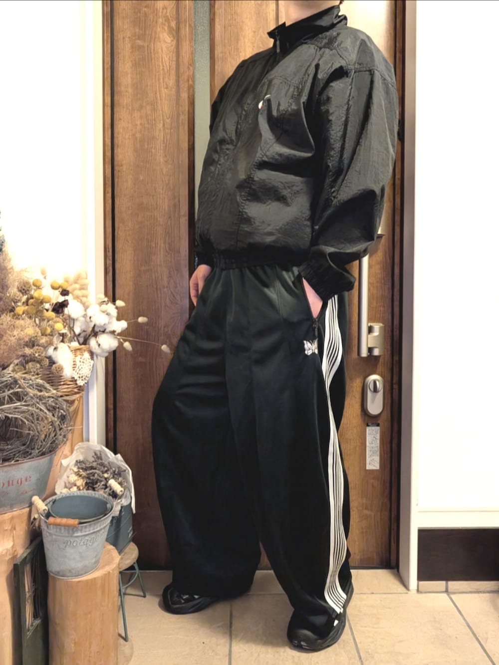 ブラック系のスニーカー、ブラック系のその他パンツ、ブラック系のナイロンジャケットを着用したメンズの春コーディネートの2枚目の写真