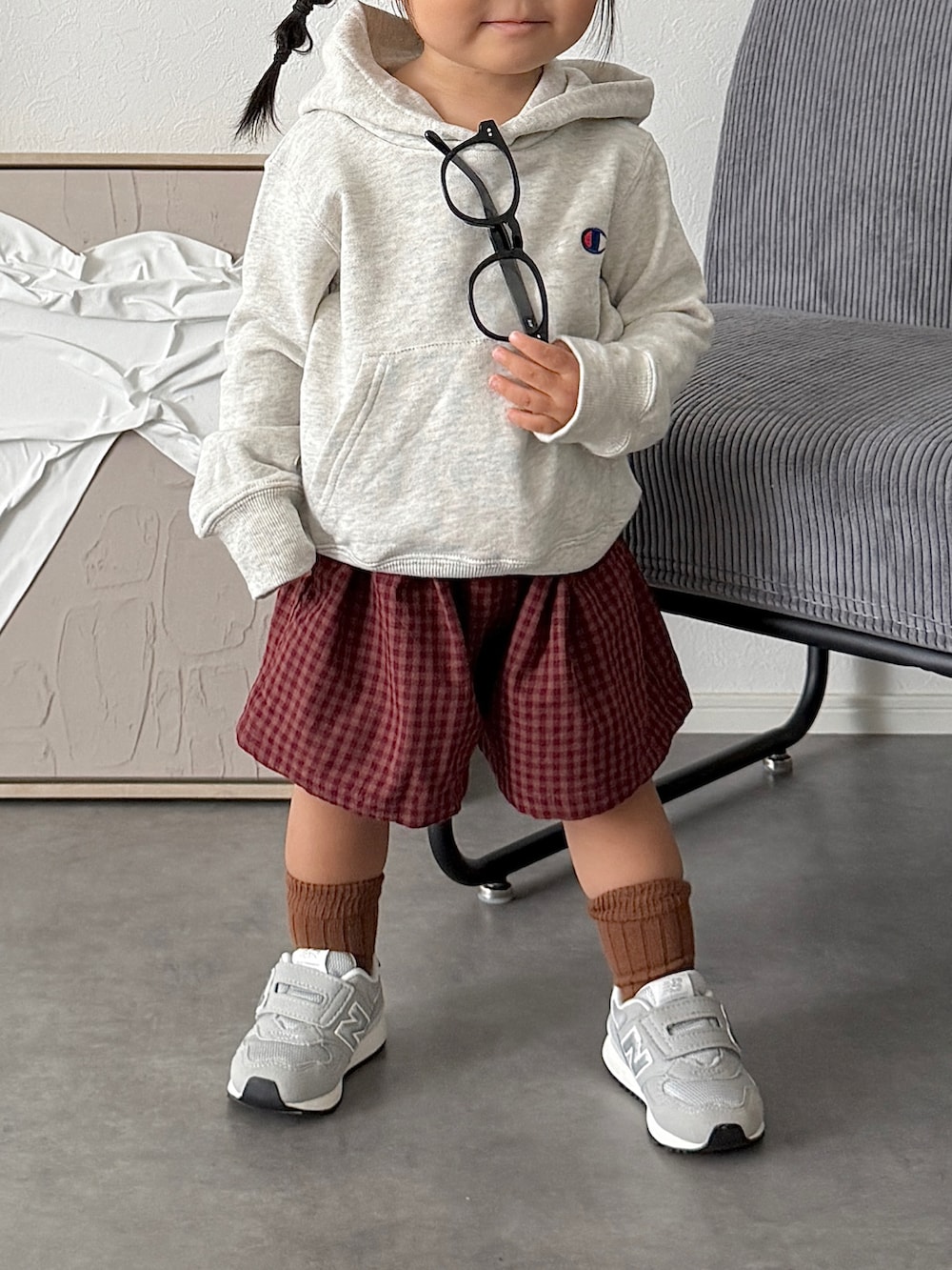 グレー系のスニーカー、グレー系のパーカー、レッド系のパンツを着用したキッズの秋コーディネートの3枚目の写真