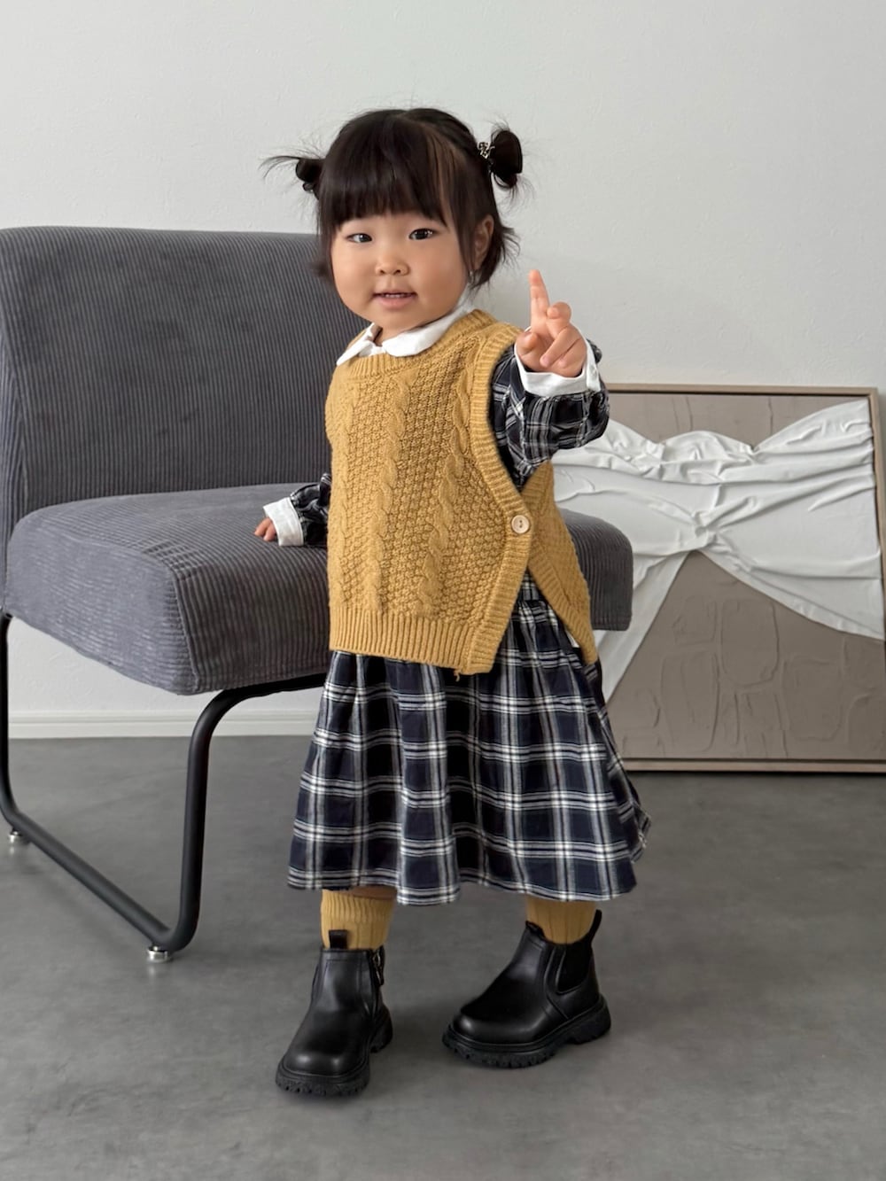 ブルー系のシャツワンピース、イエロー系のニット/セーターを着用したキッズの秋コーディネートの2枚目の写真