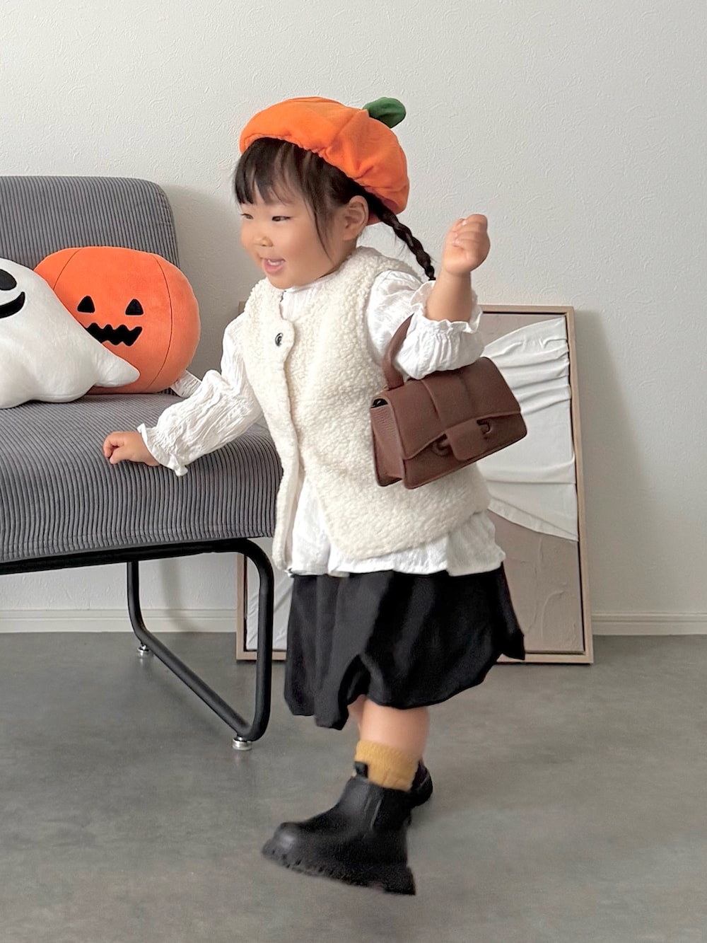 ブラック系のスカート、ホワイト系のベストを着用したキッズの秋コーディネートの3枚目の写真