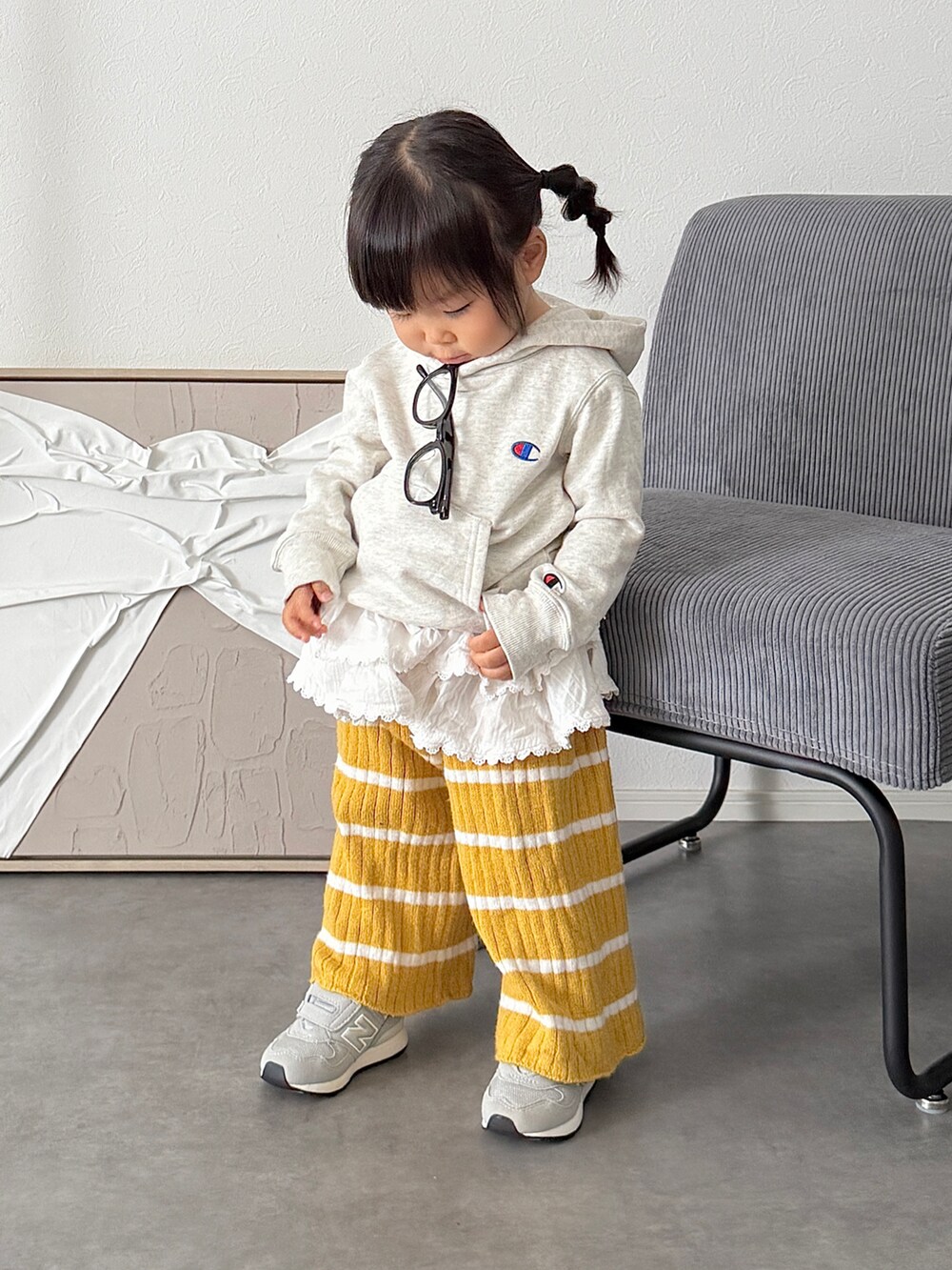 ホワイト系のスカート、グレー系のスニーカー、グレー系のパーカーを着用したキッズの秋コーディネートの2枚目の写真