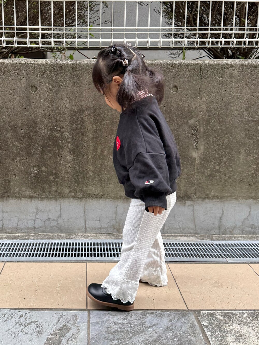 ブラック系のスウェット、ホワイト系のパンツを着用したキッズの秋コーディネートの3枚目の写真