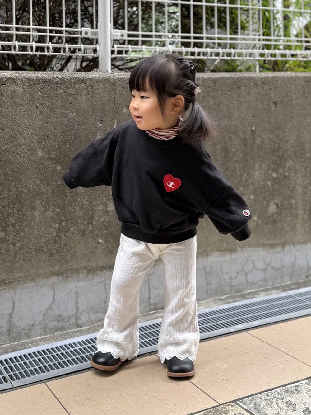 ブラック系のスウェット、ホワイト系のパンツを着用したキッズの秋コーディネートの2枚目の写真