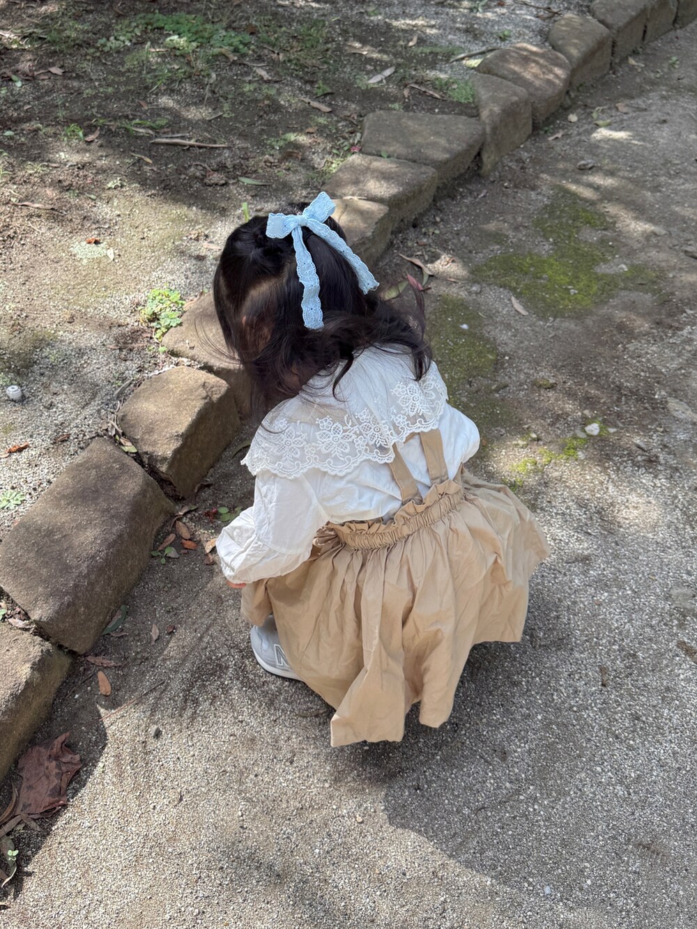 グレー系のスニーカー、ベージュ系のワンピース/ドレスを着用したキッズの秋コーディネートの3枚目の写真