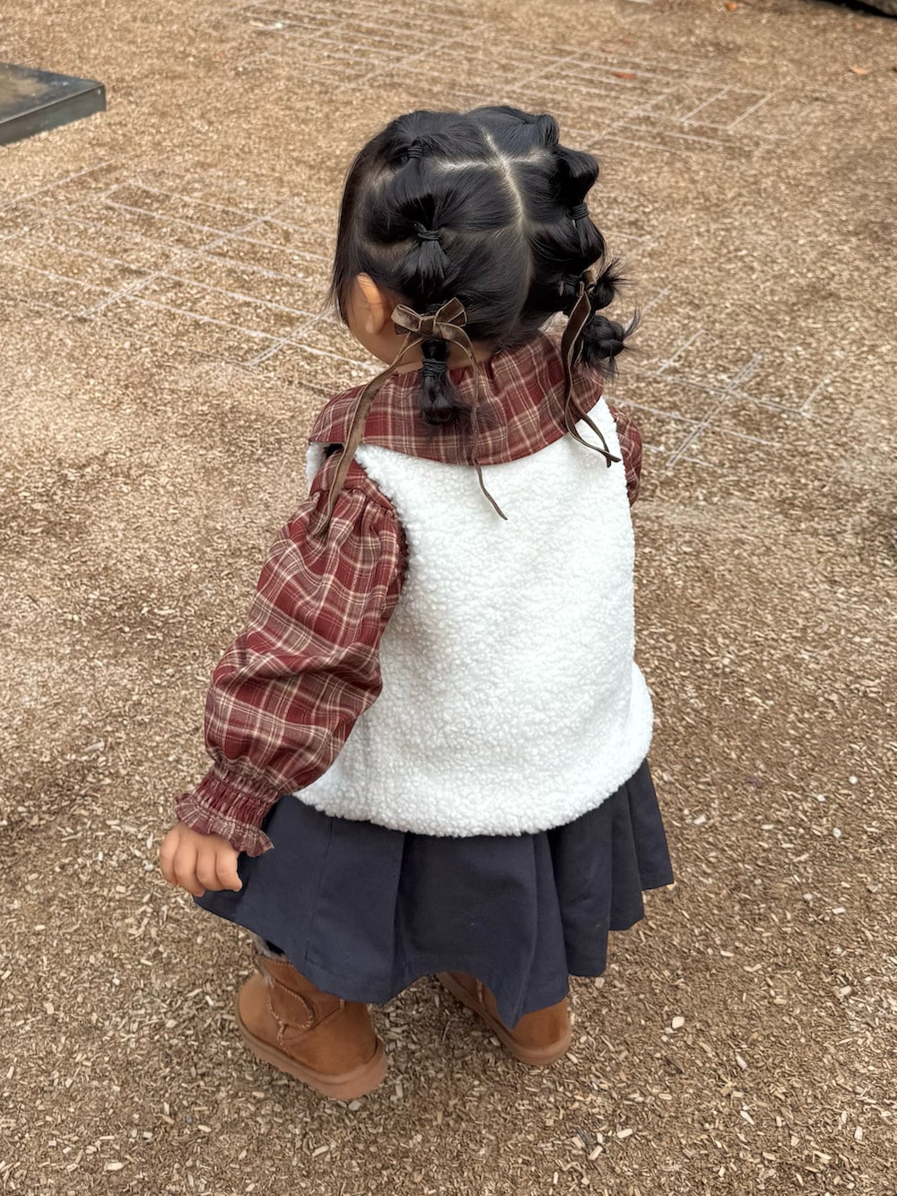 ブラウン系のシャツ/ブラウス、グレー系のジャンパースカート、イエロー系のブーツを着用したキッズの秋コーディネートの2枚目の写真