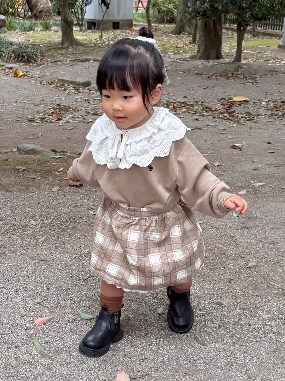 ベージュ系のスウェット、ベージュ系のスカートを着用したキッズの秋コーディネートの3枚目の写真