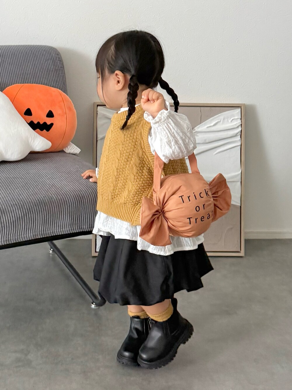 ブラック系のスカート、イエロー系のニット/セーター、オレンジ系の雑貨/ホビーを着用したキッズの秋コーディネートの2枚目の写真