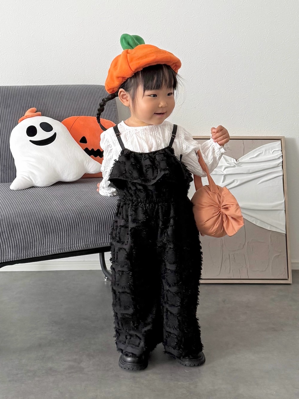 ブラック系のオールインワン・サロペット、オレンジ系の雑貨/ホビーを着用したキッズの秋コーディネートの2枚目の写真