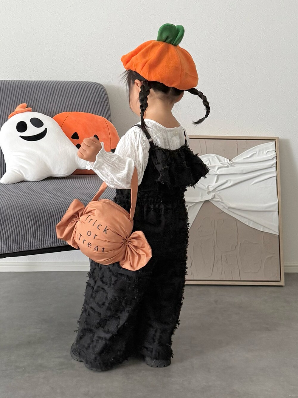 ブラック系のオールインワン・サロペット、オレンジ系の雑貨/ホビーを着用したキッズの秋コーディネートの3枚目の写真