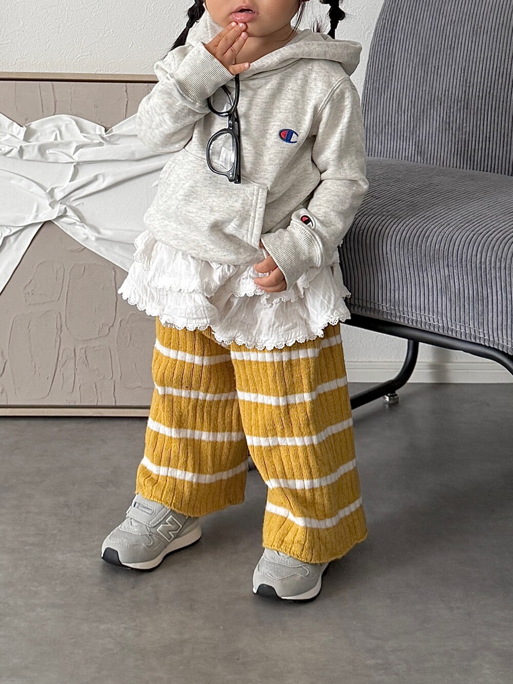 ホワイト系のスカート、グレー系のスニーカー、グレー系のパーカーを着用したキッズの秋コーディネートの3枚目の写真