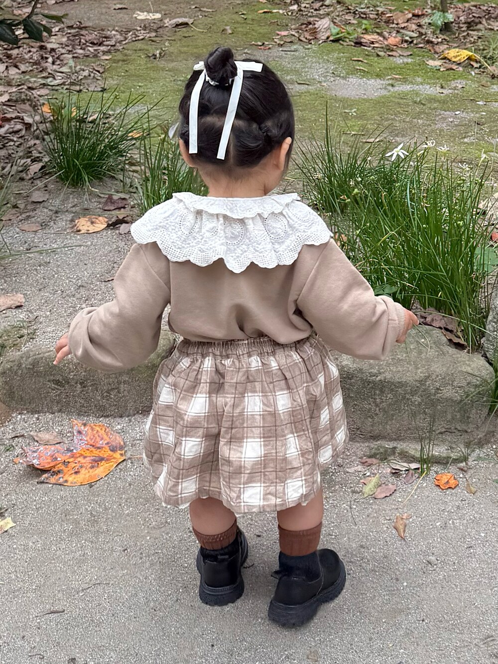 ベージュ系のスウェット、ベージュ系のスカートを着用したキッズの秋コーディネートの4枚目の写真