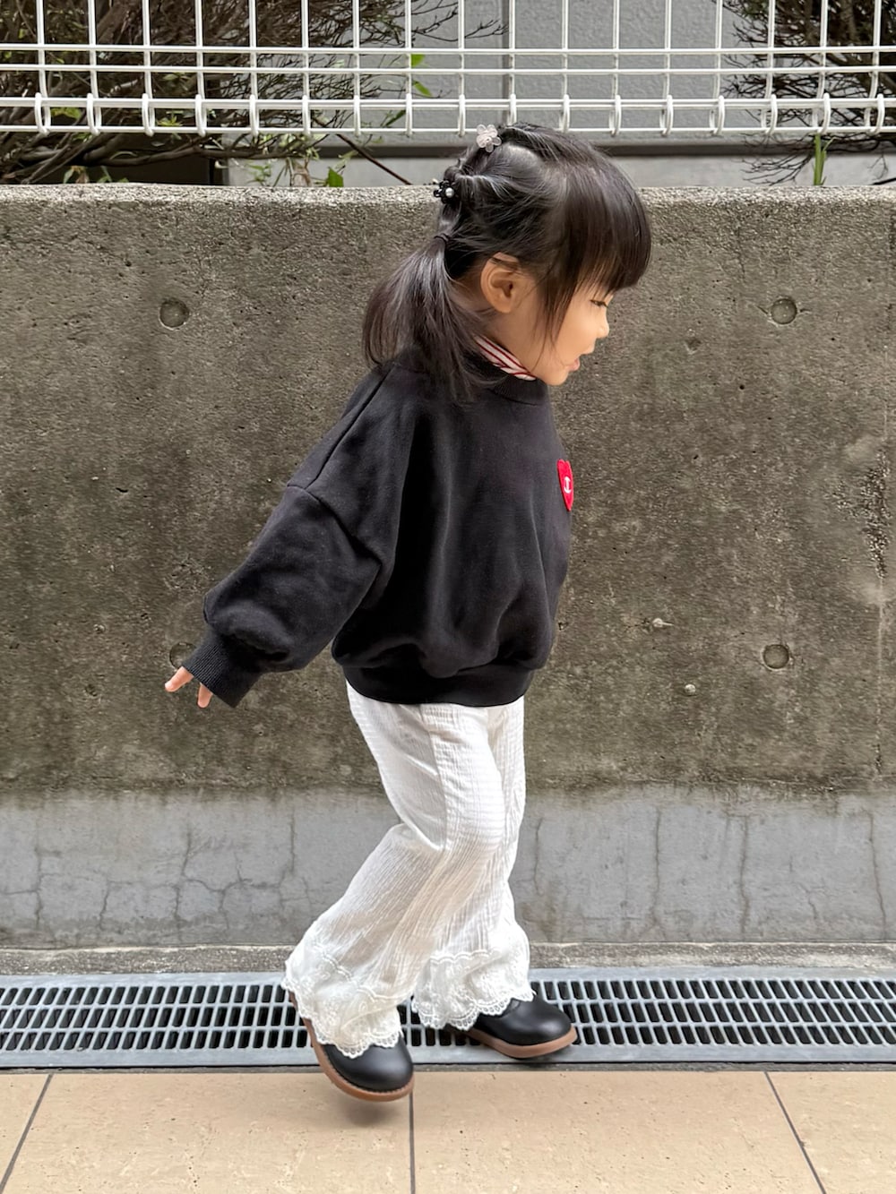 ブラック系のスウェット、ホワイト系のパンツを着用したキッズの秋コーディネートの4枚目の写真