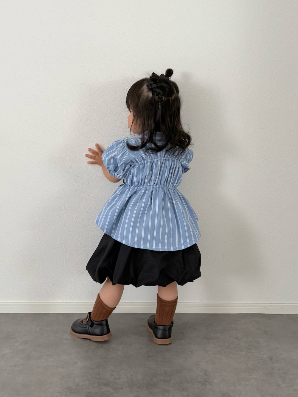 ブルー系のシャツ/ブラウス、ブラック系のスカートを着用したキッズの夏コーディネートの3枚目の写真