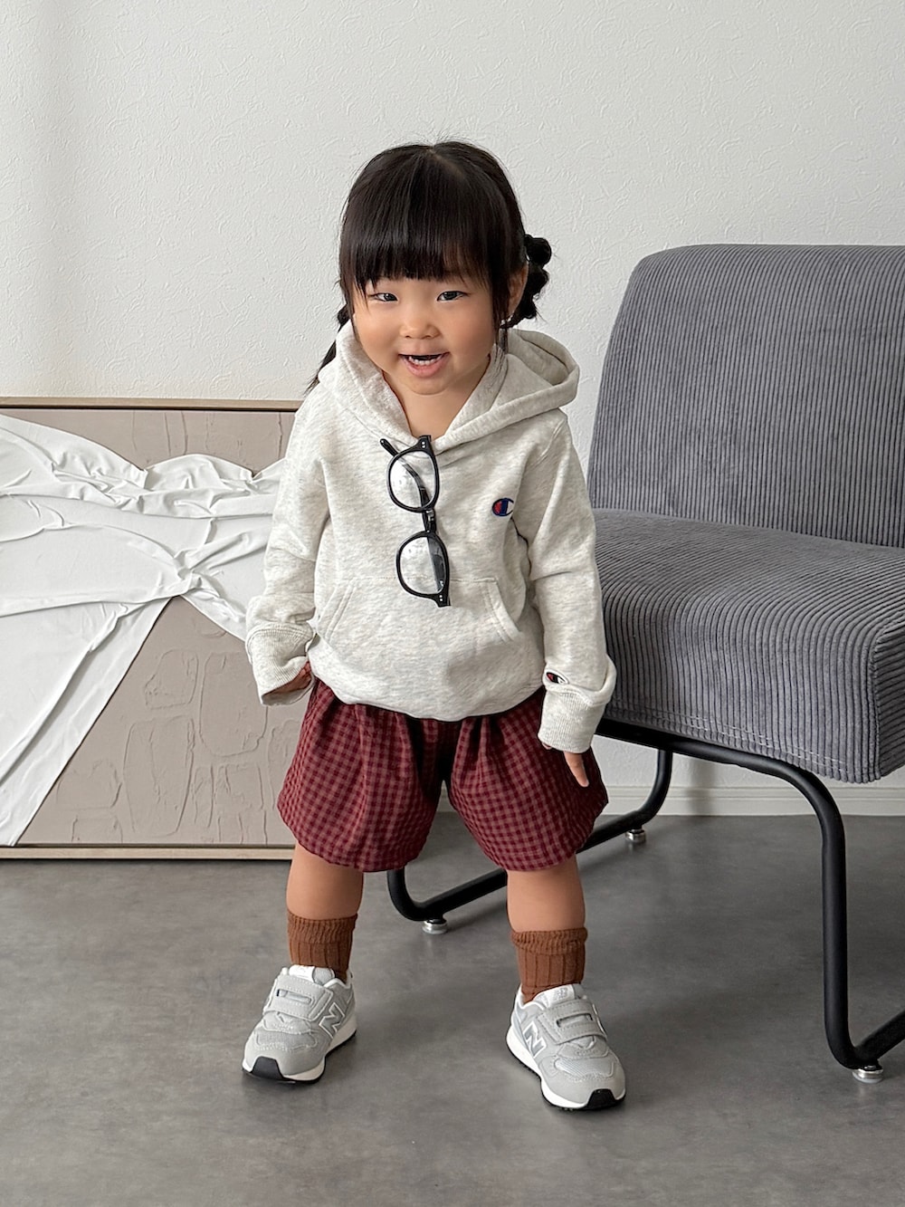 グレー系のスニーカー、グレー系のパーカー、レッド系のパンツを着用したキッズの秋コーディネートの2枚目の写真