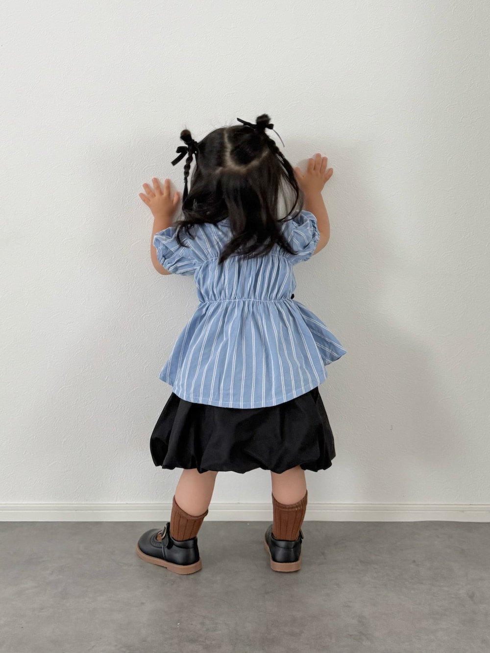 ブルー系のシャツ/ブラウス、ブラック系のスカートを着用したキッズの夏コーディネートの2枚目の写真