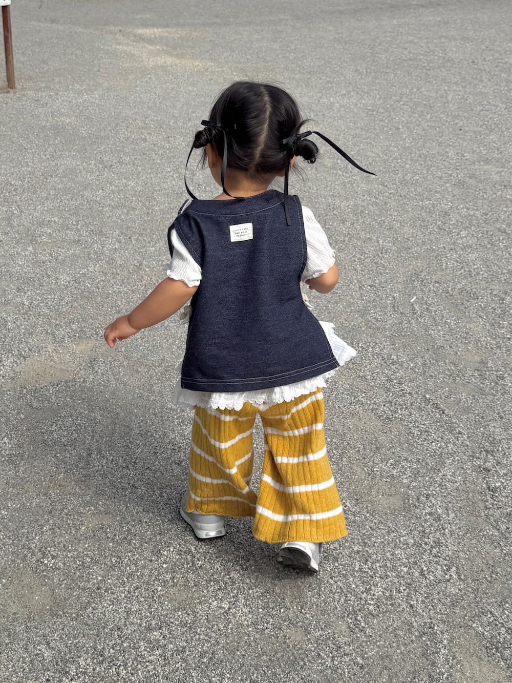 ホワイト系のTシャツ/カットソー、ホワイト系のスカート、ブルー系のベストを着用したキッズの秋コーディネートの3枚目の写真