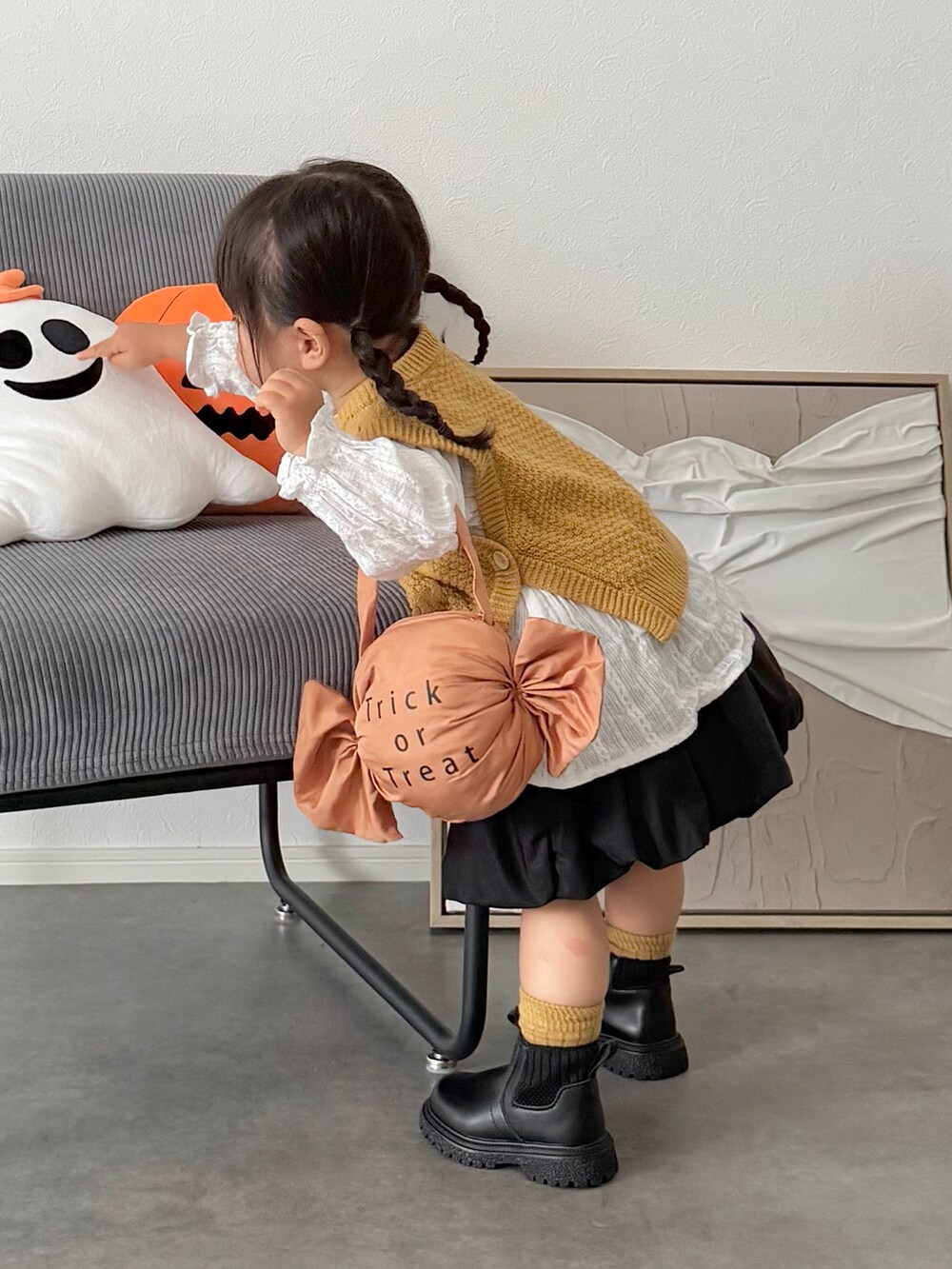 ブラック系のスカート、イエロー系のニット/セーター、オレンジ系の雑貨/ホビーを着用したキッズの秋コーディネートの3枚目の写真