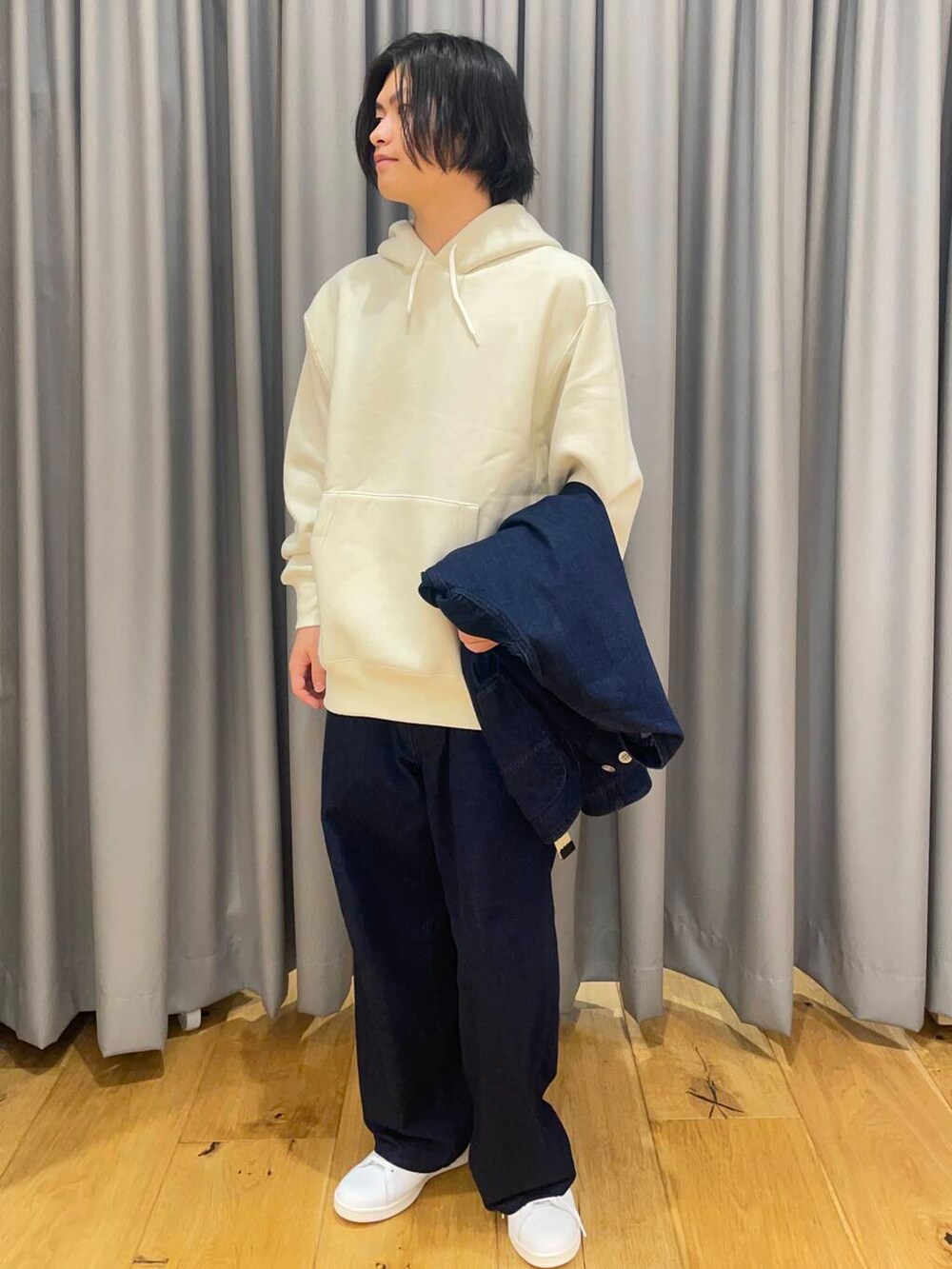 ホワイト系のスニーカー、ブルー系のデニムパンツ、ブルー系のデニムジャケットを着用したメンズの秋コーディネートの3枚目の写真