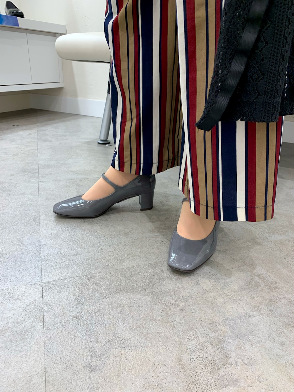 グレー系のパンプスを着用したレディースの夏コーディネートの2枚目の写真