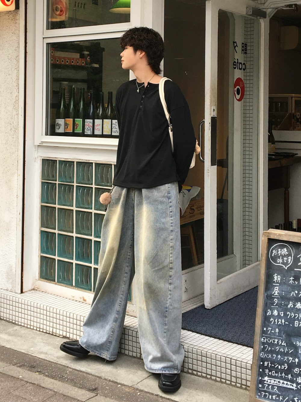 ブルー系のデニムパンツ、ブラック系のローファー、ブラック系のTシャツ/カットソーを着用したメンズの秋コーディネートの2枚目の写真