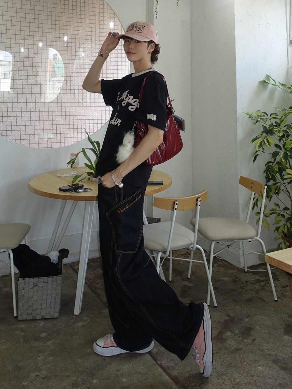 ブラック系のTシャツ/カットソー、レッド系のハンドバッグ、ブルー系のデニムパンツを着用したメンズの夏コーディネートの2枚目の写真