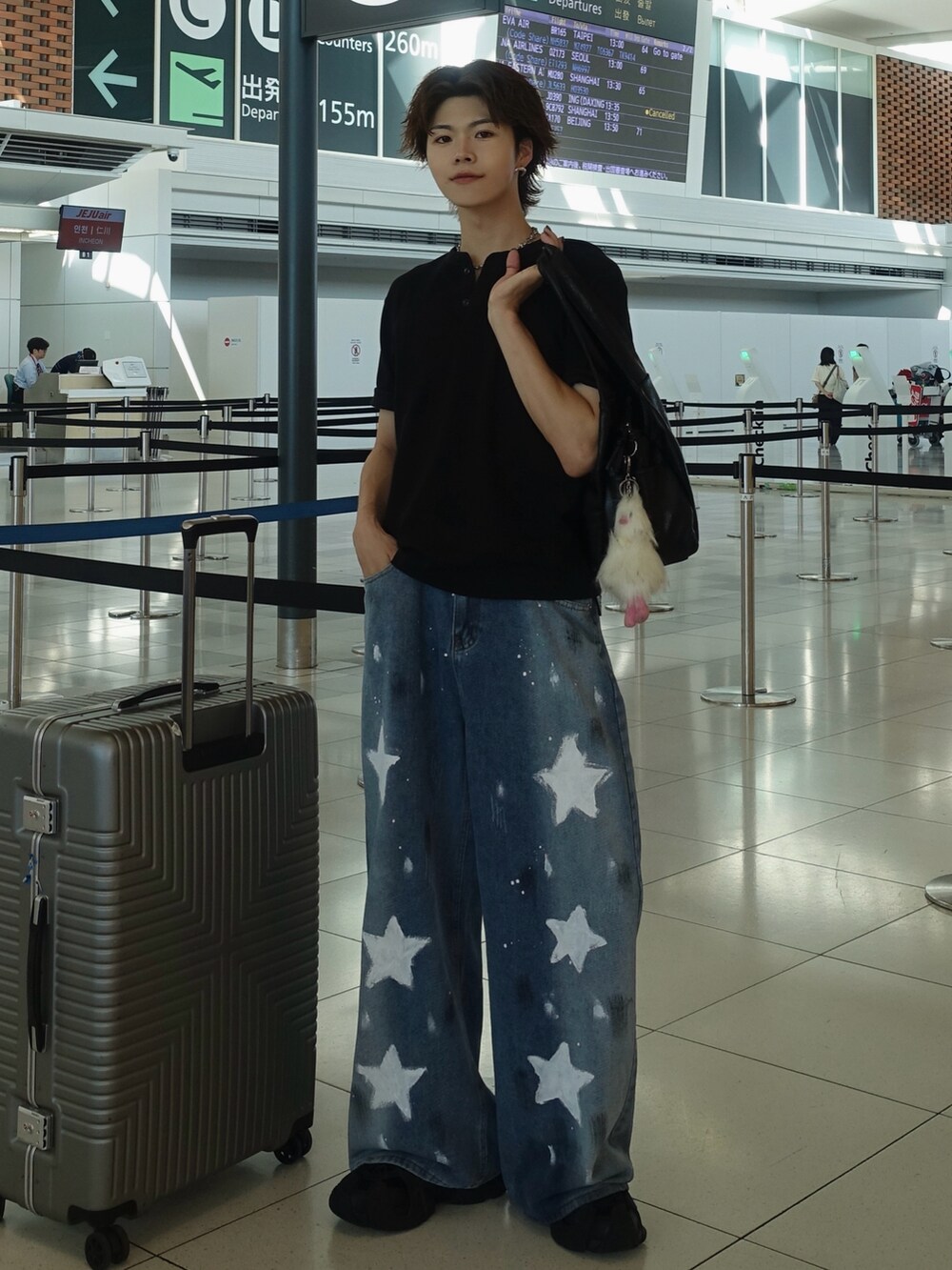 ブラック系のショルダーバッグ、ブラック系のTシャツ/カットソー、ブルー系のデニムパンツを着用したメンズの夏コーディネートの2枚目の写真