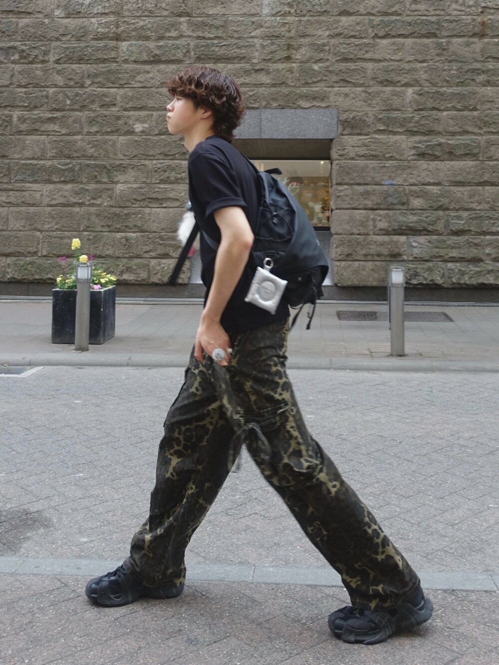 ブラック系のTシャツ/カットソー、ブラック系のボディバッグ/ウエストポーチ、ベージュ系のカーゴパンツを着用したメンズの夏コーディネートの2枚目の写真