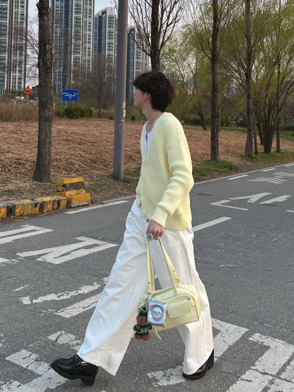 イエロー系のカーディガン/ボレロ、ホワイト系のタンクトップ、イエロー系のハンドバッグを着用したメンズの春コーディネートの2枚目の写真