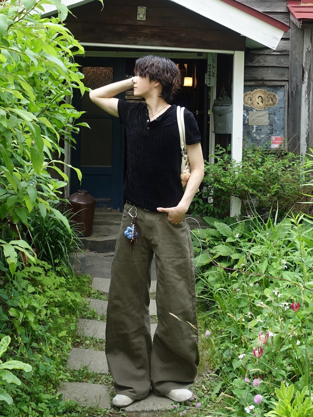 グリーン系のデニムパンツ、ブラック系のTシャツ/カットソー、ホワイト系のハンドバッグを着用したメンズの夏コーディネートの2枚目の写真