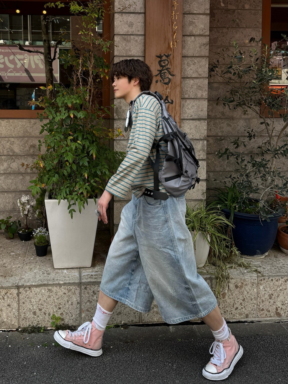 グリーン系のTシャツ/カットソー、ブルー系のデニムパンツ、ピンク系のその他シューズを着用したメンズの春コーディネートの2枚目の写真