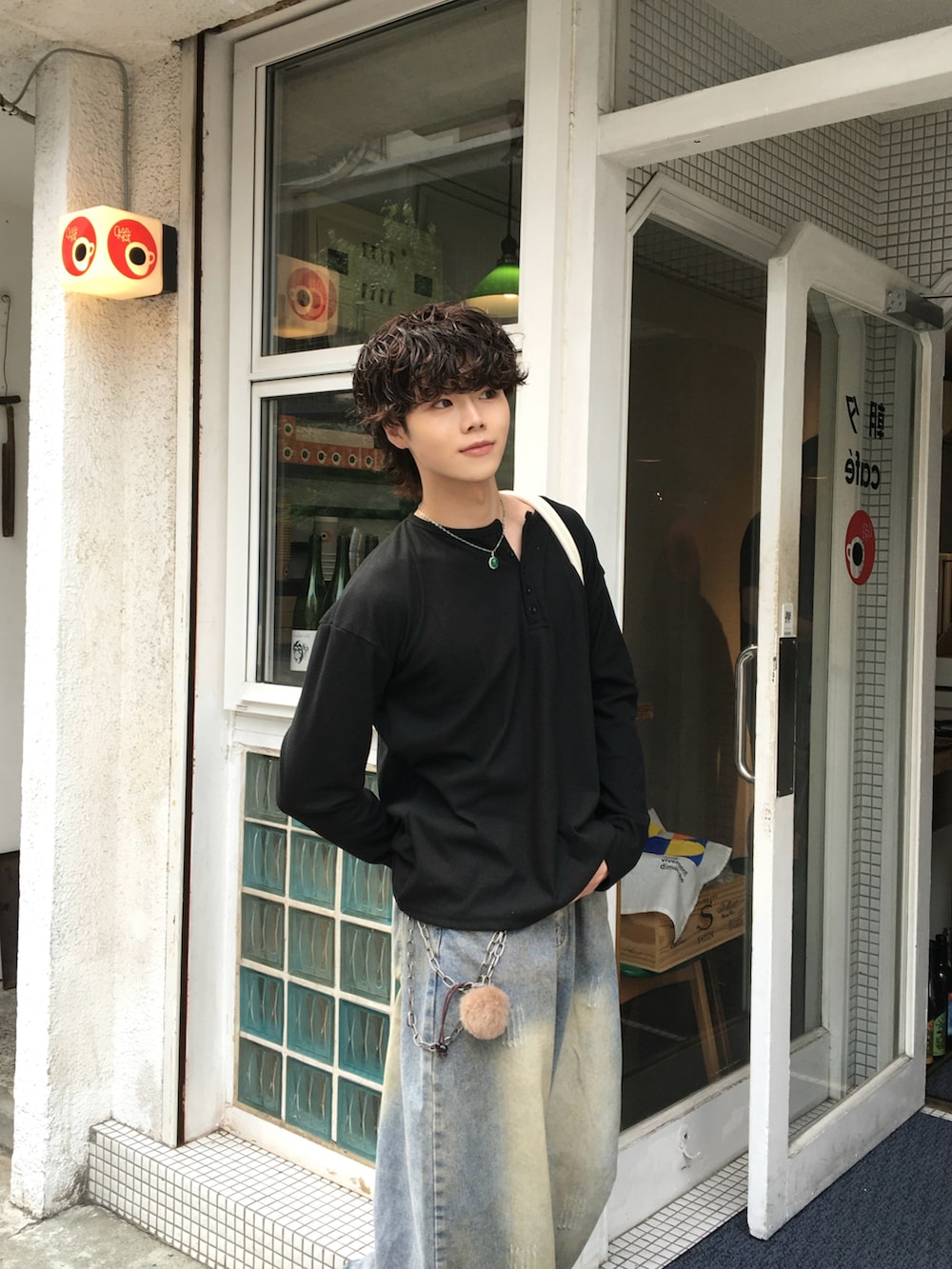 ブルー系のデニムパンツ、ブラック系のローファー、ブラック系のTシャツ/カットソーを着用したメンズの秋コーディネートの3枚目の写真